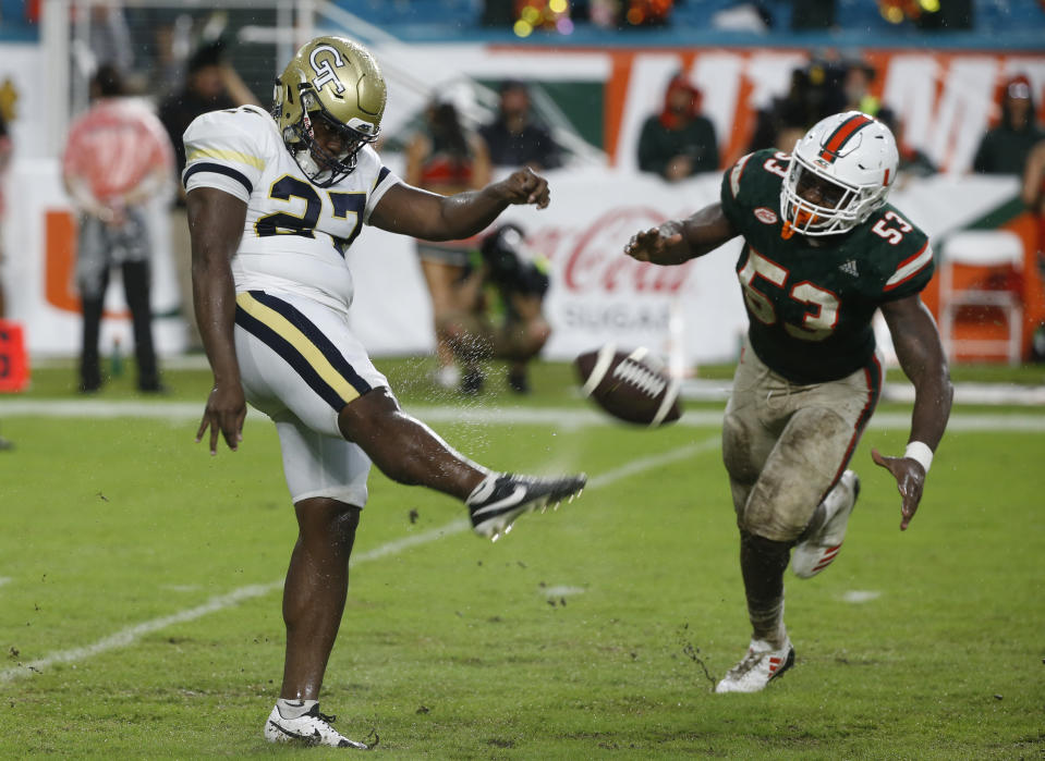 FILE - In this Oct. 14, 2017, file photo, Georgia Tech punter Pressley Harvin III (27) kicks the ball as Miami linebacker Zach McCloud (53) attempts to block during the second half of an NCAA college football game in Miami Gardens, Fla. Harvin, who packs 263 pounds on his 6-foot frame, set school and ACC single-season records last year with a 48-yard net punting average. He can throw the football just as far and as accurately as he can punt it. (AP Photo/Wilfredo Lee, File)