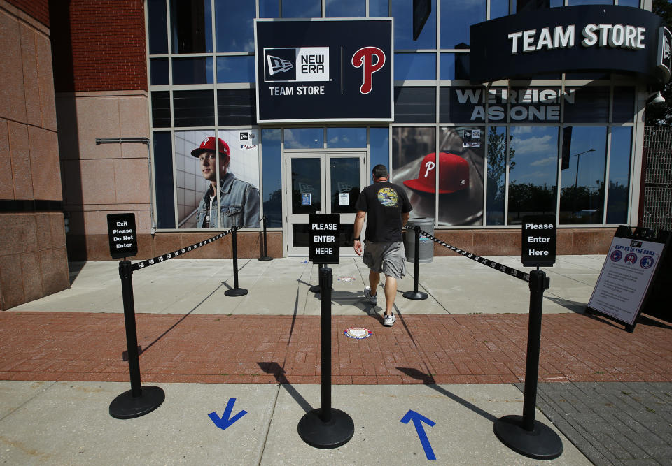A person walks toward the Philadelphia Phillies team store at Citizens Bank Park on Monday, July 27, 2020, in Philadelphia. The Phillies' game against the New York Yankees on Monday was postponed after several members of the Miami Marlins tested positive for the coronavirus. (Yong Kim/The Philadelphia Inquirer via AP)