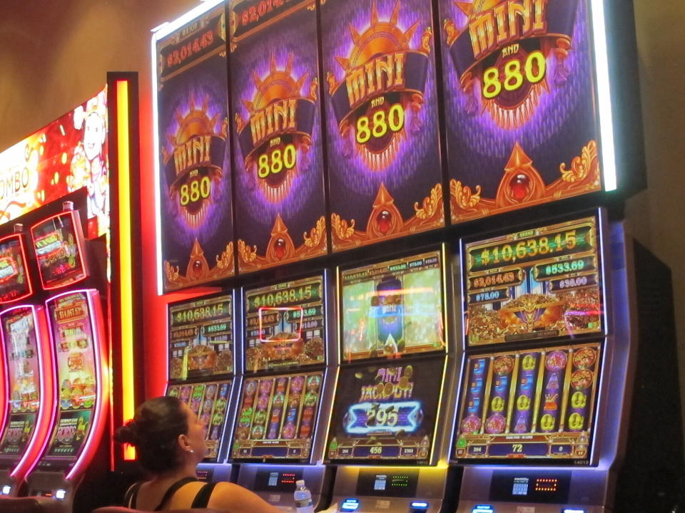 This June 23, 2021 photo shows a woman playing a slot machine at Bally's casino in Atlantic City N.J. On Oct. 25, 2021, panelists at the East Coast Gaming Congress in Atlantic City pondered what the casino floor of the future should look like, including how to attract the next generation of gamblers. (AP Photo/Wayne Parry)