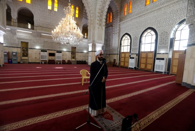 An Iraqi cleric calls for the prayer in an empty mosque, as Friday prayers were suspended following the spread of the coronavirus disease (COVID-19), in Baghdad