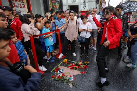 A Michael Jackson impersonator dances next to Michael Jackson's star on the Hollywood Walk of Fame ten years after the death of child star turned King of Pop in Los Angeles, California