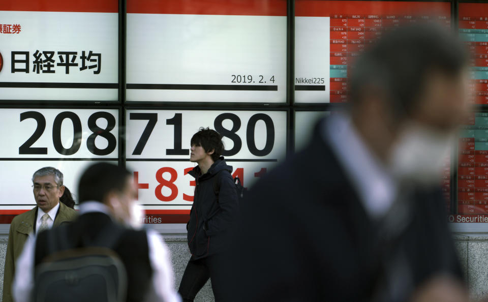 People walk past an electronic stock board showing Japan's Nikkei 225 index at a securities firm in Tokyo Monday, Feb. 4, 2019. Asian markets were mixed Monday as traders questioned an imminent meeting between American and Chinese officials to work on disagreements ranging from technology development to trade. (AP Photo/Eugene Hoshiko)