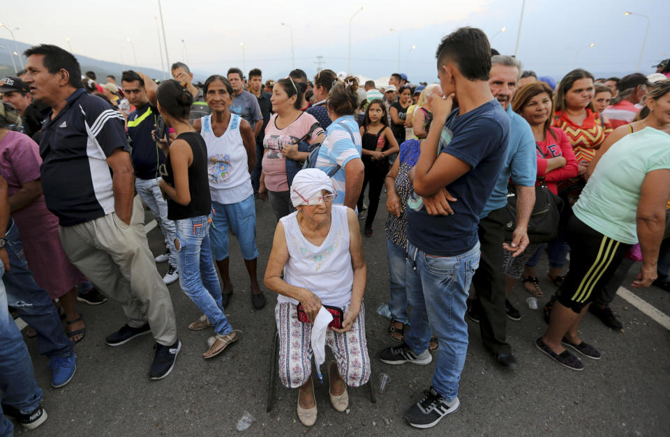 People line up to receive bags with food subsidized by the Nicolas Maduro's government near the international bridge of Tienditas on the outskirts of Urena, Venezuela, Monday, Feb. 11, 2019. Nearly three weeks after the Trump administration backed an all-out effort to force out President Maduro, the embattled socialist leader is holding strong and defying predictions of an imminent demise. (AP Photo/Fernando Llano)