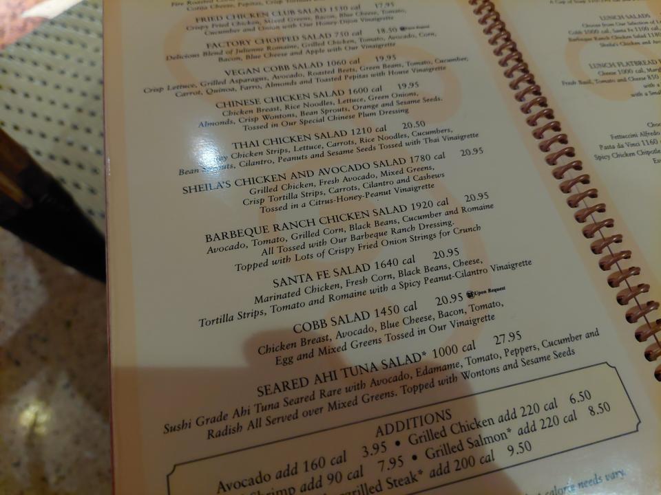 A photo of the Cheesecake Factory's menu. The page is open on salad