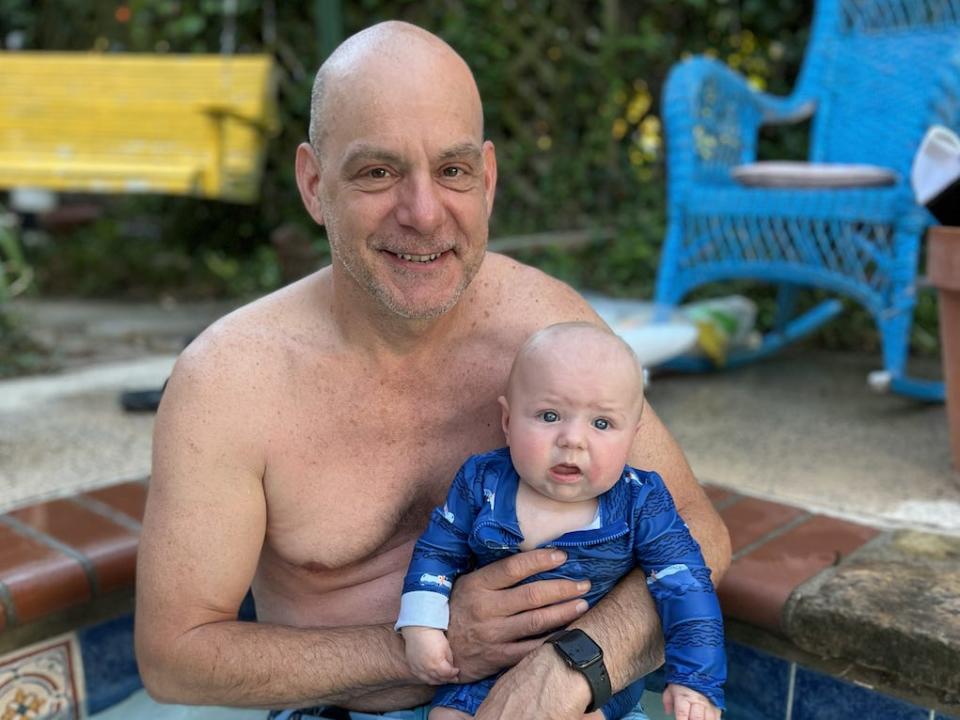 Man holding baby in the pool