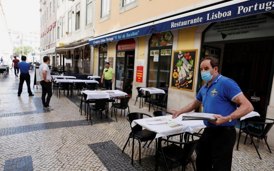 A waiter waits for customers at a restaurant, amid the coronavirus disease (COVID-19) outbreak, in downtown Lisbon, Portugal - Reuters