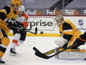 Pittsburgh Penguins goaltender Tristan Jarry (35) watches the puck off the stick of Philadelphia Flyers' Scott Laughton (21) during the second period of an NHL hockey game Thursday, March 4, 2021, in Pittsburgh. (AP Photo/Keith Srakocic)