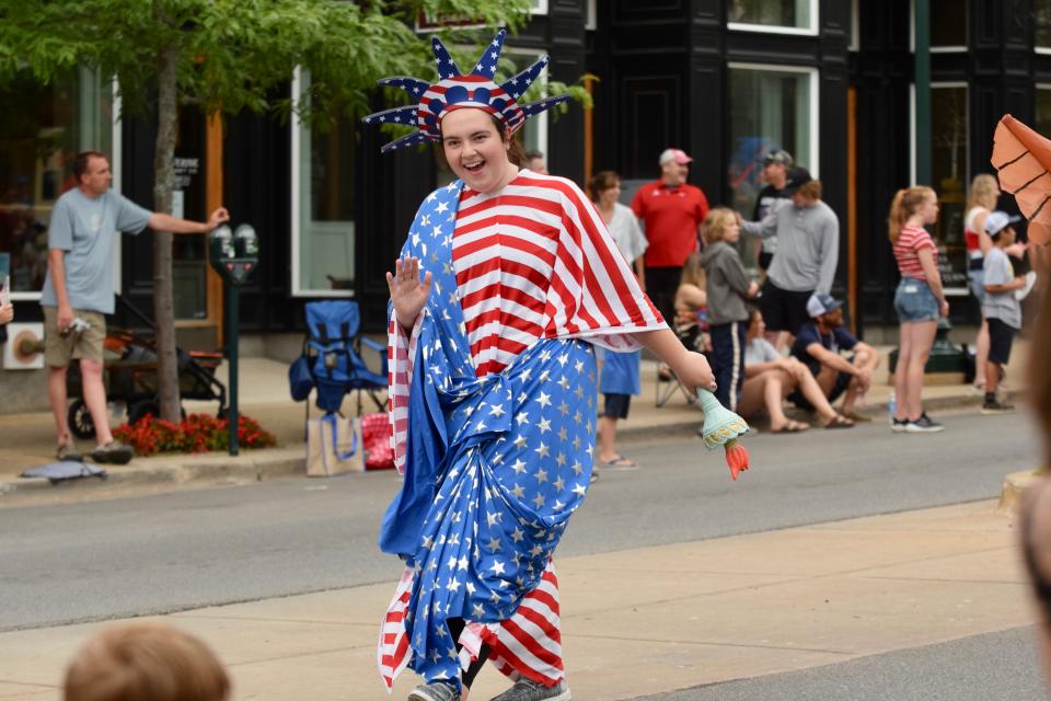 A woman wearing an American flag Statue of Liberty costume waves to kids during the Petoskey Fourth of July parade on Mitchell Street in downtown Petoskey on July 4.