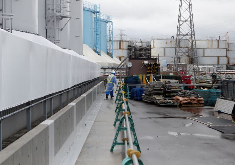 A worker is seen near storage tanks for radioactive water at tsunami-crippled Fukushima Daiichi nuclear power plant in Okuma town, Fukushima prefecture, Japan