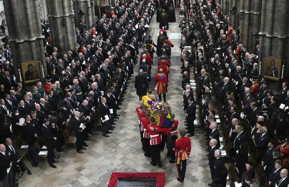 The coffin of Queen Elizabeth II is carried into Westminster Abbey for her funeral in central London, Monday, Sept. 19, 2022. The Queen, who died aged 96 on Sept. 8, will be buried at Windsor alongside her late husband, Prince Philip, who died last year. (AP Photo/Frank Augstein, Pool)