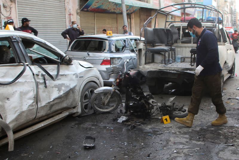 A member of a crime scene unit surveys after a blast in Quetta