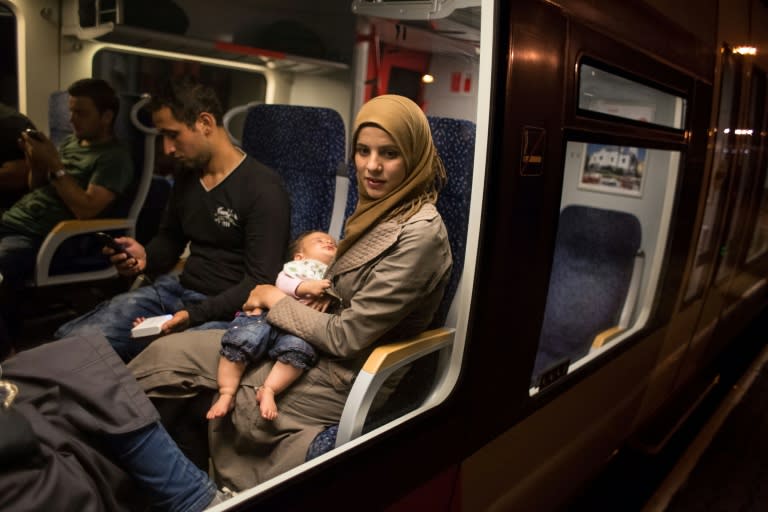 Migrants sit on the train from Budapest to Vienna at the Austrian - Hungarian border in Hegyeshalom on August 31, 2015