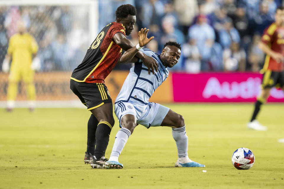 Sporting Kansas City forward Willy Agada, front right, leans into Seattle Sounders defender Yeimar Gómez, left, during the second half of an MLS soccer match on Saturday, March 25, 2023, in Kansas City, Kan. (AP Photo/Nick Tre. Smith)