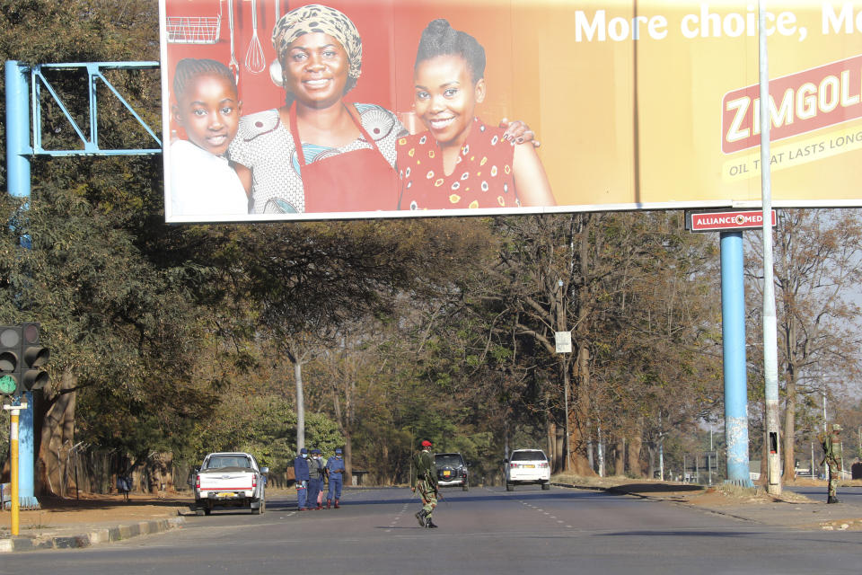 Armed soldiers patrol a street in Harare, Friday, July, 31, 2020. Zimbabwe's capital, Harare, was deserted Friday, as security agents vigorously enforced the country's lockdown amidst planned protests.Police and soldiers manned checkpoints and ordered people seeking to get into the city for work and other chores to return home. (AP Photo/Tsvangirayi Mukwazhi)