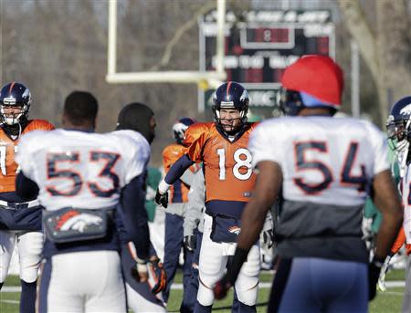 Denver Broncos quarterback Peyton Manning (18) does stretching exercises with teammates linebackers Steven Johnson (53) and Brandon Marshall (54) during their practice session for the Super Bowl at the New York Jets Training Center in Florham Park, New Jersey, January 29, 2014. REUTERS/Ray Stubblebine