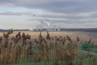 Smoke rises from chimneys of the Turow power plant located by the Turow lignite coal mine near the town of Bogatynia, Poland, Tuesday, Nov. 19, 2019. The Turow lignite coal mine in Poland has an impact on the environment and communities near the border of three neighboring countries, the Czech Republic, Germany and Poland. Plans to further expand the huge open pit mine have caused alarm among residents who fear things might get even worse. (AP Photo/Petr David Josek)