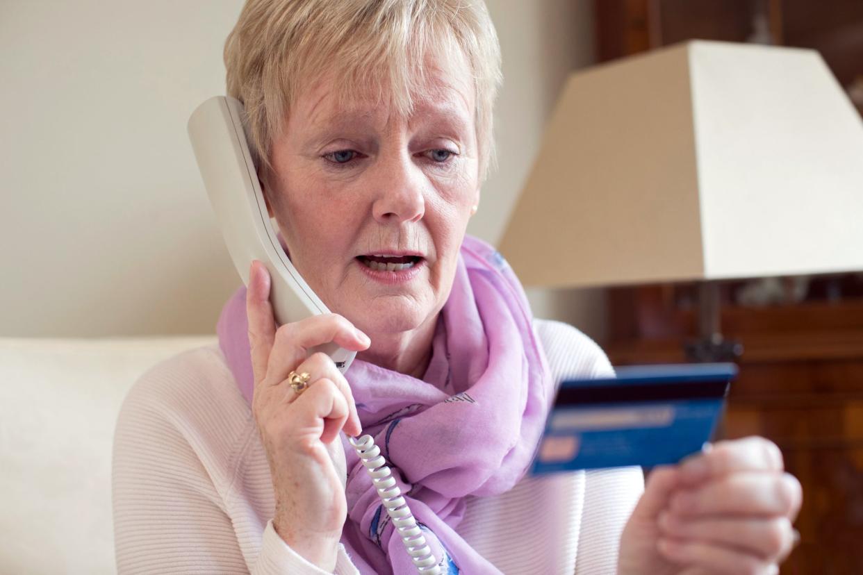 senior woman giving credit card details on phone
