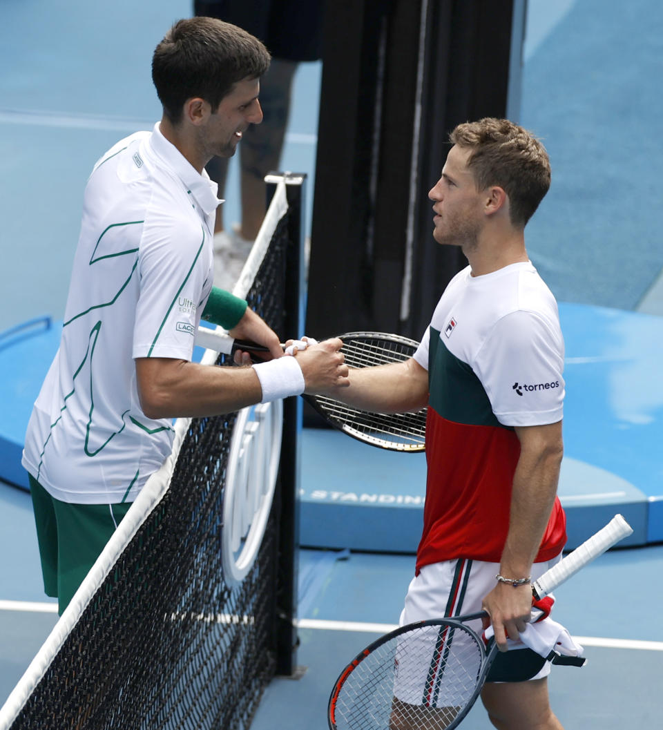 Serbia's Novak Djokovic, left, is congratulated by Diego Schwartzman of Argentina after winning their fourth round singles match at the Australian Open tennis championship in Melbourne, Australia, Sunday, Jan. 26, 2020. (AP Photo/Andy Wong)
