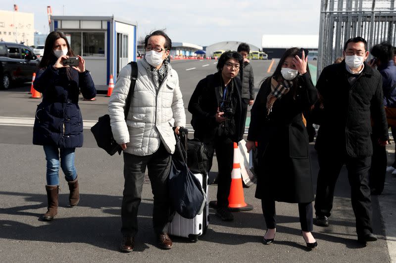 Los pasajeros con mascarillas salen del crucero Diamond Princess en la terminal de cruceros del muelle Daikoku en Yokohama, al sur de Tokio, Japón, el 19 de febrero de 2020