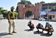 AMRITSAR, INDIA - MARCH 25: Police personnel make curfew violators perform sit-ups, on the first day of the 3-week national lockdown to check the spread of coronavirus, at Hall Gate on March 25, 2020 in Amritsar, India. Prime Minister Narendra Modi on Tuesday announced a complete lockdown of the entire country for 21 days in an unprecedented drastic measure to try halt the spread of coronavirus as the number of cases in the country crossed 500. (Photo by Sameer Sehgal/Hindustan Times via Getty Images)