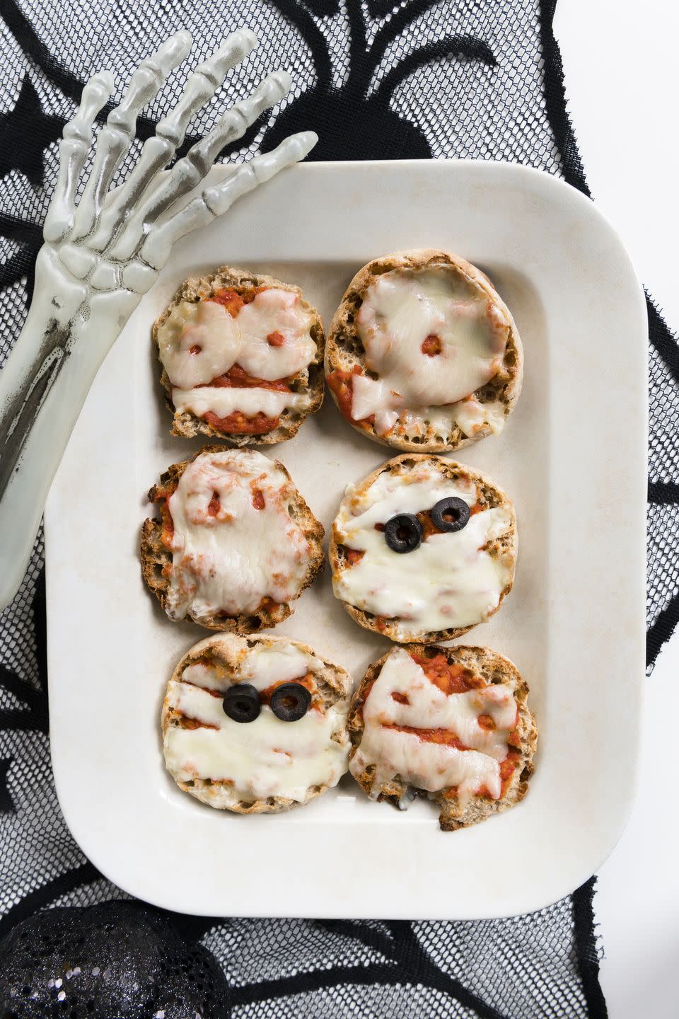 <p>You can serve your guests a batch of spooky personal pizzas by decorating homemade English muffins with sauce, cheese, and black olive eyes and baking in a preheated oven set to 375 degrees Fahrenheit for 10 minutes. And if you're looking to save on prep time, then you can always use store-bought English muffins instead. </p><p>Get the <a href="https://www.womansday.com/food-recipes/food-drinks/recipes/a40296/homemade-english-muffins-3873/" rel="nofollow noopener" target="_blank" data-ylk="slk:Homemade English Muffin recipe" class="link "><strong>Homemade English Muffin recipe</strong></a>. </p>