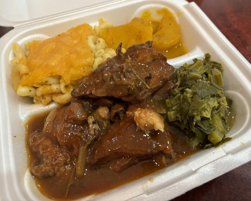 A plate of Brown Stew Chicken with collards, mac-and-cheese and curry potatoes from Jamrock Sports Bar & Grill at 417 College Road in Wilmington, N.C.