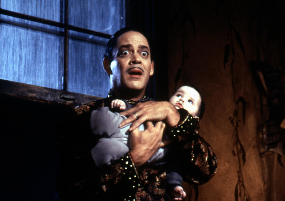 Gomez holds the baby, looking terrified