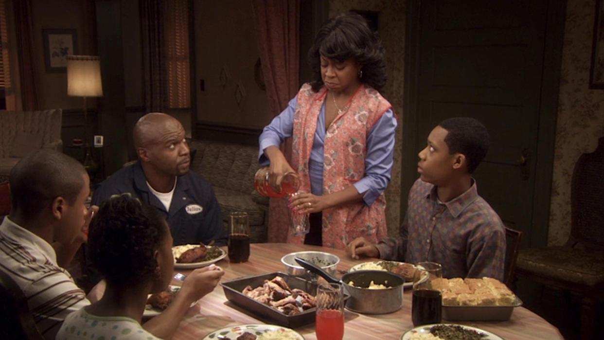  The Rock family sitting around the dinner table, with Julius and Chris warily eyeing Rochelle as she pours herself a drink in Everybody Hates Chris. 