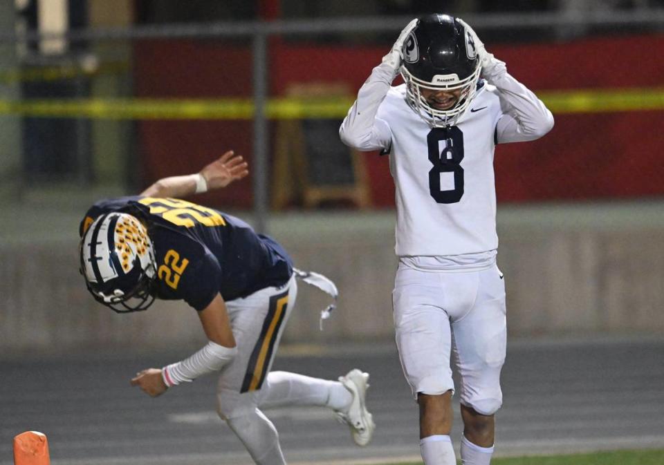 Redwood’s Isaiah Galaviz, right, shows frustration after Sunnyside quaterback Tanner Wilson, background, scored a touchdown at the start of the third quarter in the Central Section D2 playoff game Friday, Nov. 3, 2023 in Fresno. Sunnyside won the game 39-21.