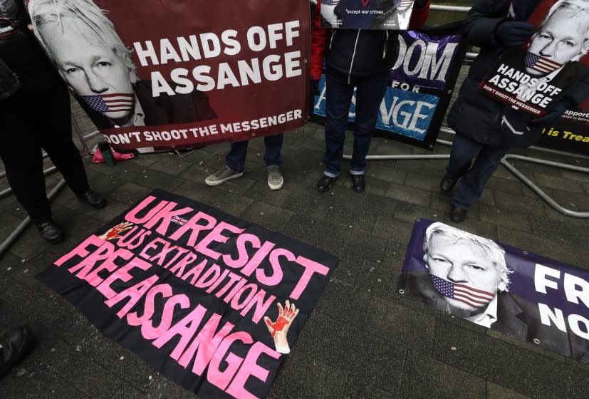 FILE - In this Thursday, Jan. 23, 2020 file photo, demonstrators supporting Julian Assange hold banners outside Westminster Magistrates Court in London. WikiLeaks founder Julian Assange is set to fight for his freedom in a British after a decade of legal drama, as he challenges American authorities' attempt to extradite him on spying charges over the site's publication of secret U.S. military documents. Lawyers for Assange and the U.S. government will face off in London Monday, Sept. 7, 2020 at an extradition hearing that was delayed by the coronavirus pandemic. (AP Photo/Kirsty Wigglesworth, File)