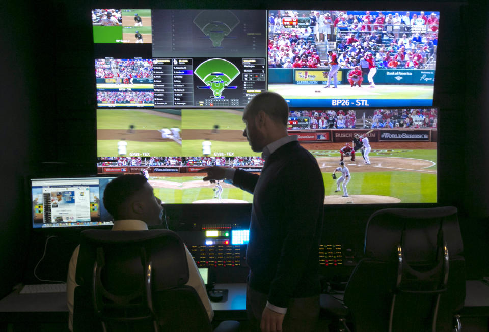 Two technicians work in a booth during a preview of Major League Baseball's Replay Operations Center, in New York, Wednesday, March 26, 2014. Less than a week before most teams open, MLB is working on the unveiling of its new instant replay system, which it hopes will vastly reduce incorrect calls by umpires. (AP Photo/Richard Drew)