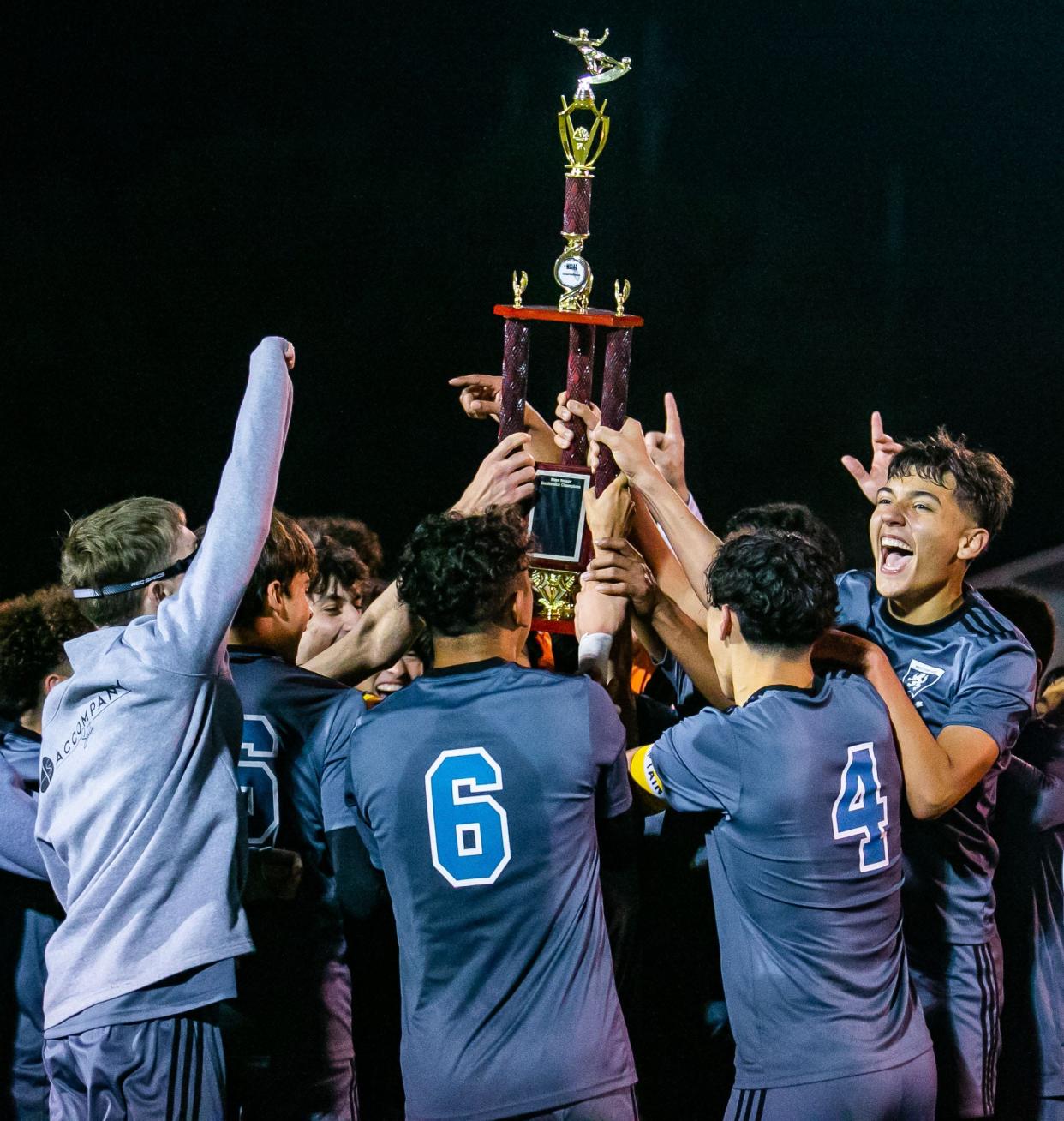 West Port players celebrate after receiving the trophy after West Port defeated Forest 3-1 in the MCIAC Soccer Final in Booster Stadium Friday night, January 14, 2022 in Ocala, FL. [Doug Engle/Ocala Star-Banner]2022

Oca 011422 Mciacbsoccerfinal