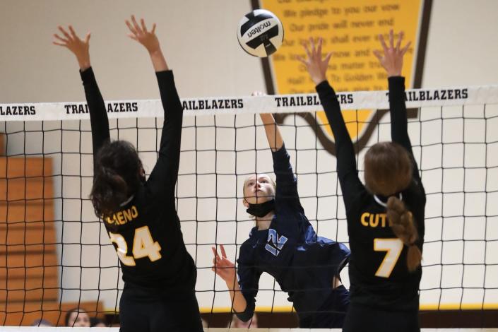 Redwood's Audrey Hyde spikes against Golden West's Roxanne Moreno (24) and Kylie Cutler during a West Yosemite League high school volleyball match on Thursday Sept. 23, 2021.