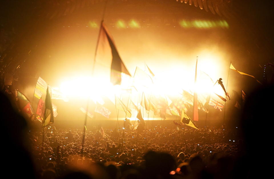 Revellers dance in front of the Pyramid stage as Kanye West performs at Worthy Farm in 2015.
