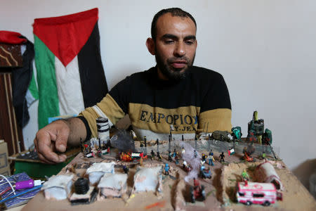 Palestinian diorama artist Majdi Abu Taqeya works on miniature figures he carves from remnants of Israeli ammunition collected from the scenes of border protests along the Israel-Gaza border, in the central Gaza Strip March 11, 2019. Picture taken March 11, 2019. REUTERS/Ibraheem Abu Mustafa