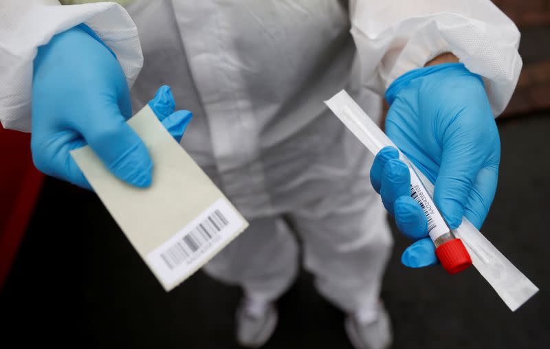 A member of the community swabbing team holds a testing kit before he carries out a doorstep COVID-19 testing following the outbreak of the coronavirus disease (COVID-19) in Chadderton, Britain