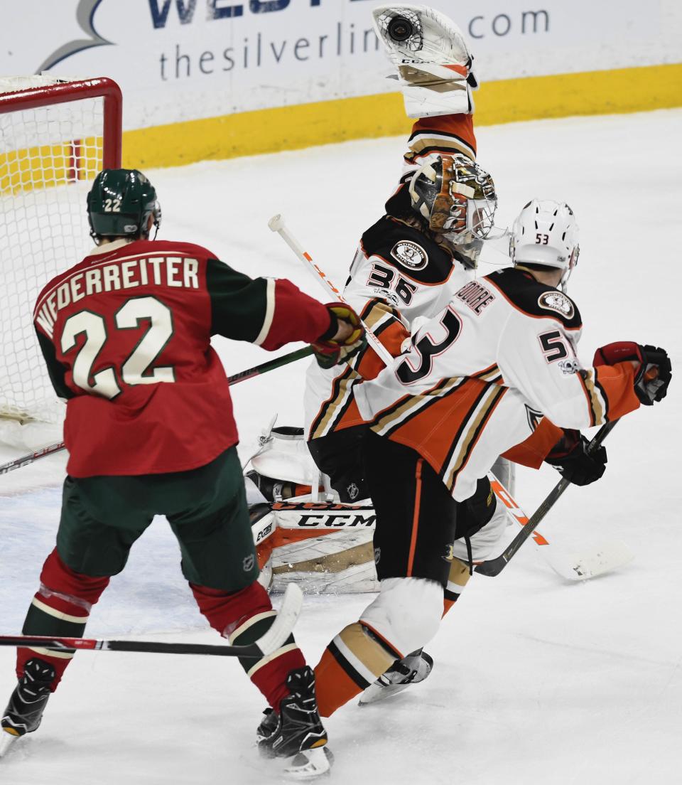 Anaheim Ducks' goalie John Gibson, center, makes a glove save on a shot as Ducks' Shea Theodore, right defends against Minnesota Wild's Nino Niederreiter (22), of Switzerland, in the first period of an NHL hockey game, Tuesday, Feb. 14, 2017, in St. Paul, Minn. (AP Photo/Tom Olmscheid)