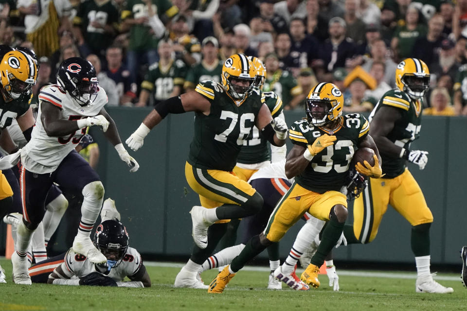 Green Bay Packers running back Aaron Jones (33) runs from Chicago Bears linebacker Nicholas Morrow (53) during the second half of an NFL football game Sunday, Sept. 18, 2022, in Green Bay, Wis. (AP Photo/Morry Gash)