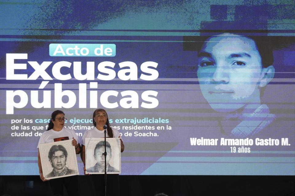 Beatriz Mendez, right, mother of Weimar Castro one of the 19 young people who were falsely presented as guerrillas killed in combat by the Colombian army during the country's internal conflict, speaks during an act of recognition and public apology by the state for their extrajudicial execution, in Bogota, Colombia, Tuesday, Oct. 3, 2023. (AP Photo/Fernando Vergara)
