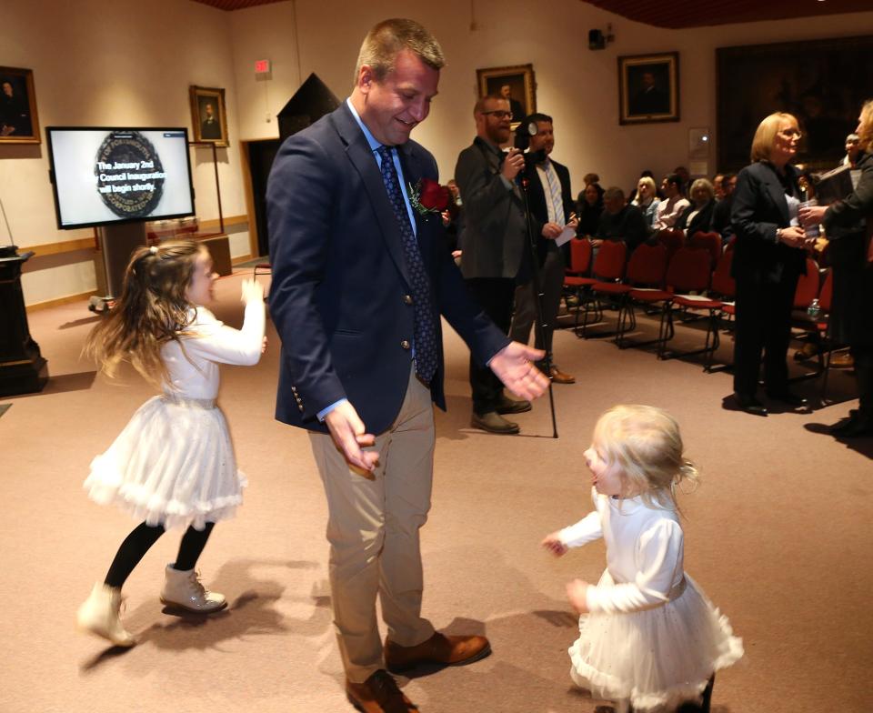 Mayor Deaglan McEachern's two daughters, Tiernan and Aurelia, run circles around City Councilor Rich Blalock before the inauguration and swearing-in ceremony for city elected officials Tuesday, Jan. 2, 2024.