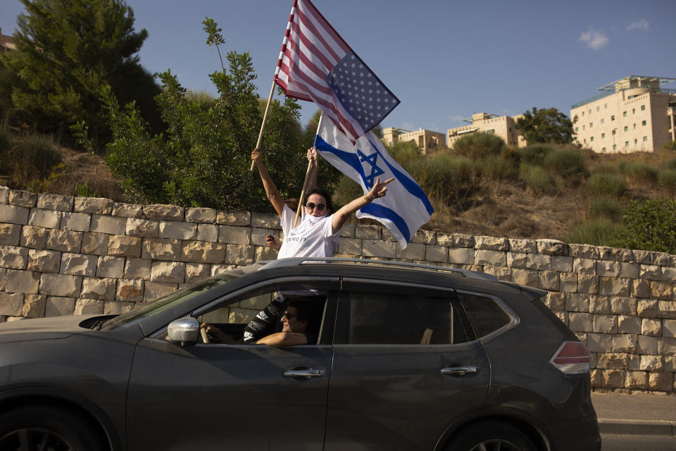 Supporters of U.S. President Donald Trump for re-election wave an American and an Israeli flag from a car headed for a rally outside of the U.S. Embassy, in Jerusalem, Tuesday, Oct. 27, 2020. (AP Photo/Maya Alleruzzo)