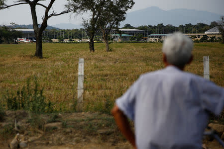 A man looks on after trucks arrived at a warehouse, where international humanitarian aid for Venezuela will be stored according to authorities, near the Tienditas cross-border bridge between Colombia and Venezuela, in Cucuta, Colombia February 7, 2019. REUTERS/Marco Bello