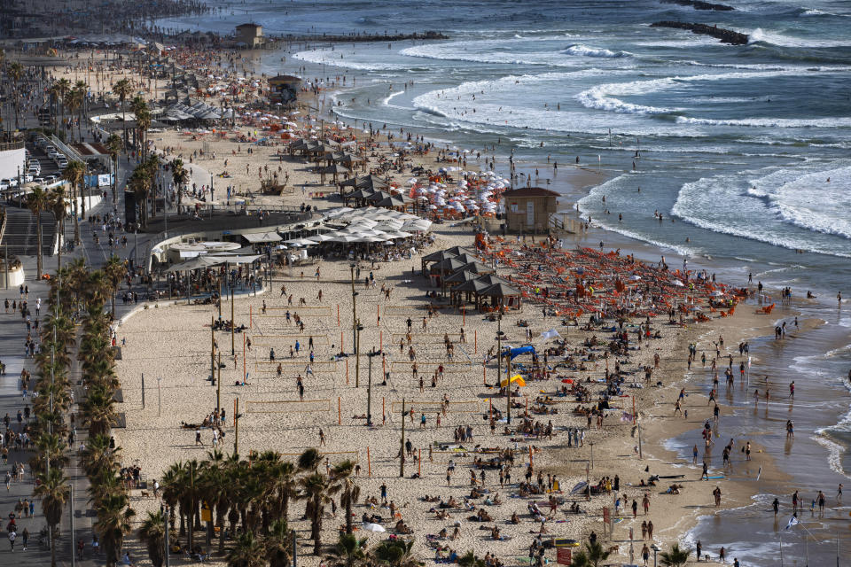 People enjoy the beach front in Tel Aviv, Israel, Saturday, May 22, 2021. A cease-fire took effect early Friday after 11 days of heavy fighting between Israel and Gaza's militant Hamas rulers that was ignited by protests and clashes in Jerusalem. (AP Photo/Oded Balilty)