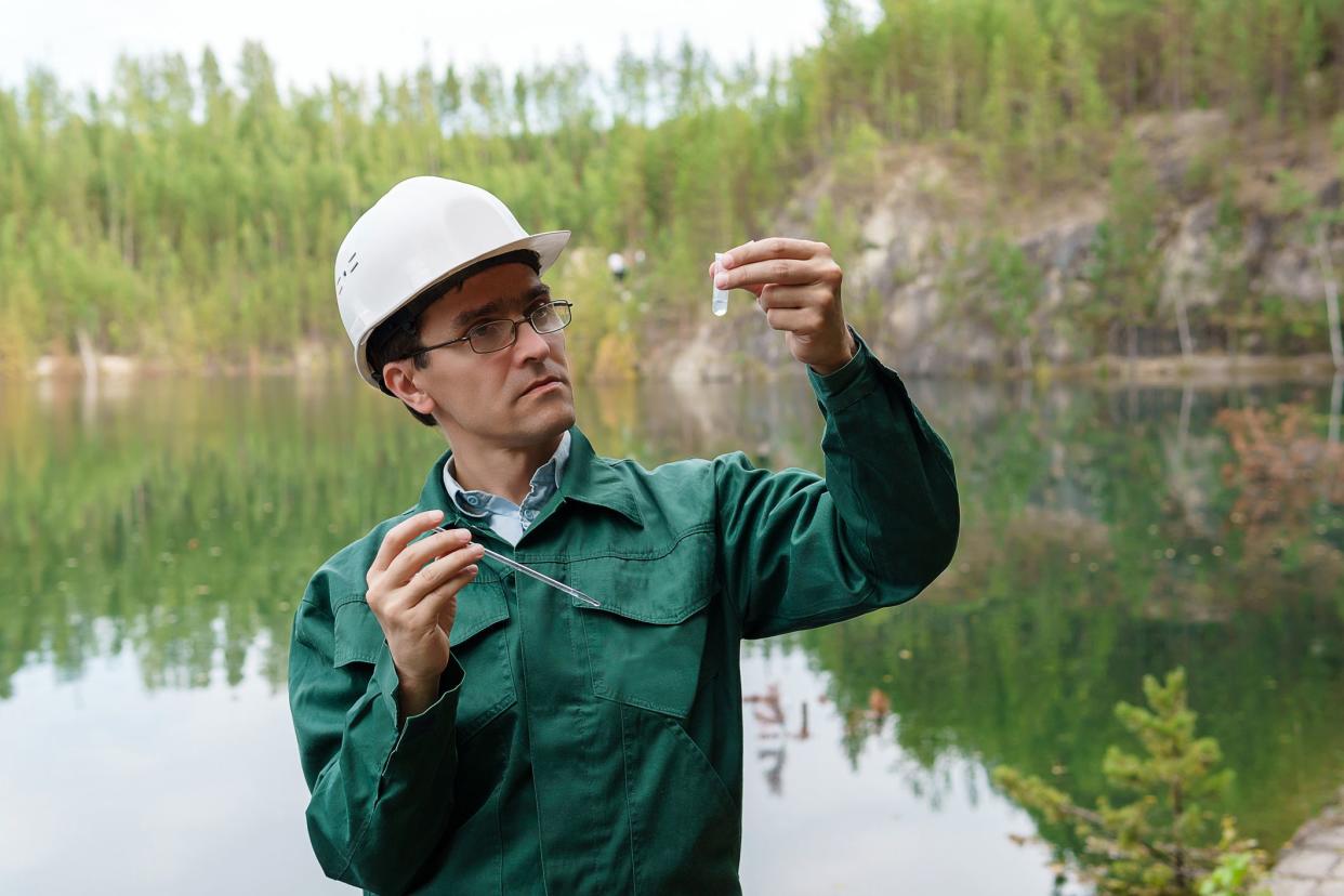 industrial ecologist or hydrologist visually evaluates the response of a water sample from lake at the site of a flooded quarry