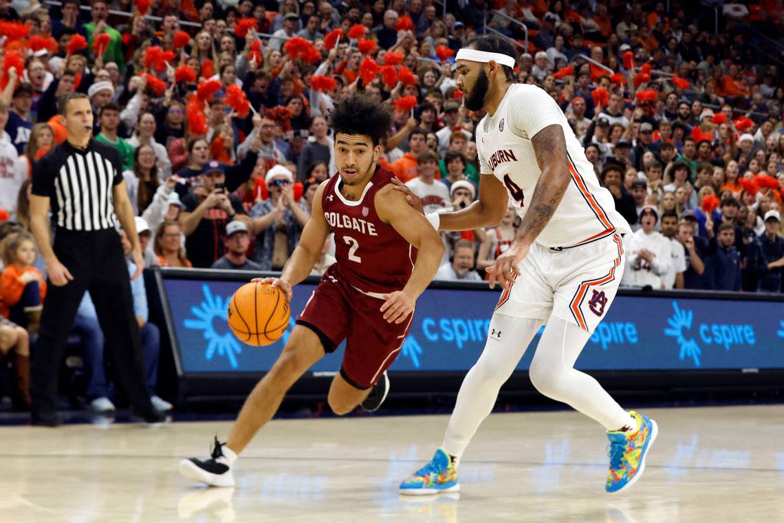 Colgate guard Braeden Smith (2) dribbles around Auburn forward Johni Broome (4) during the first half of an NCAA college basketball game Friday, Dec. 2, 2022, in Auburn, Ala. (AP Photo/Butch Dill)