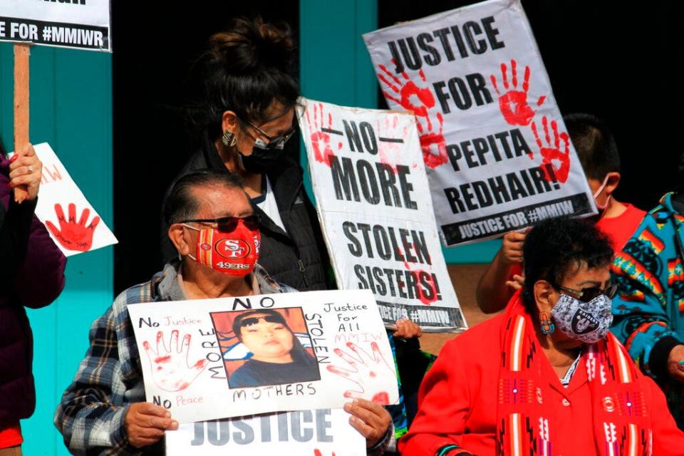 Family members of missing and slain Native Americans gathered to watch New Mexico Gov. Michelle Lujan Grisham sign legislation during a ceremony in Albuquerque, N.M., on Thursday, Feb. 24, 2022. New Mexico's governor isn't backing down on her decision to nominate a former tribal leader who once faced sexual assault charges to head the state's Indian Affairs Department. Advocates who have worked to address violence against Native American women and bring more attention to missing persons cases within their communities are pushing the state Senate to hold a confirmation hearing for James Mountain.