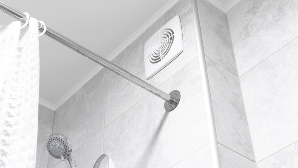 An exhaust fan in a bathroom next to a shower