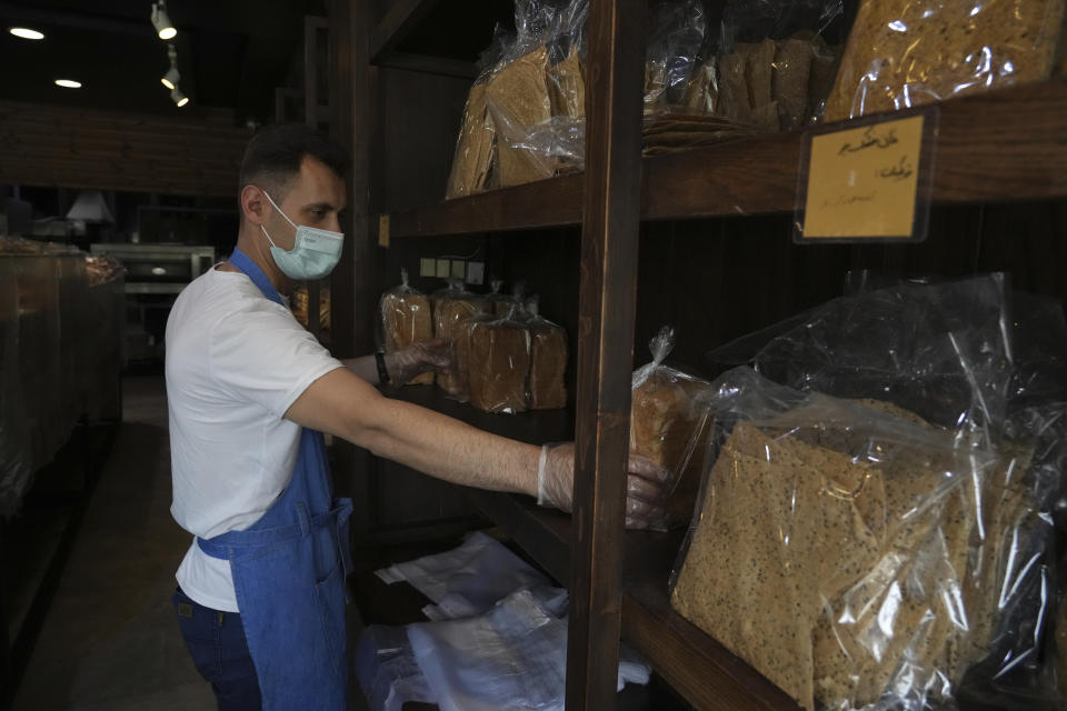 Bakery worker Mojtaba Motallebi put bread packs in shelves at a bakery in Tehran, Iran, Wednesday, May 11, 2022. Iran abruptly raised prices as much as 300% for a variety of staples such as cooking oil, chicken, eggs and milk on Thursday. (AP Photo/Vahid Salemi)