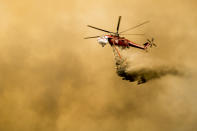 <p>Helicopters pass through smoke from the holy fire burning through Orange and Riverside county that has increased to over 18,000 acres in Lake Elsinore, Calif., on Aug. 10, 2018. (Photo: Maria Alejandra Cardona/Los Angeles Times via Getty Images) </p>