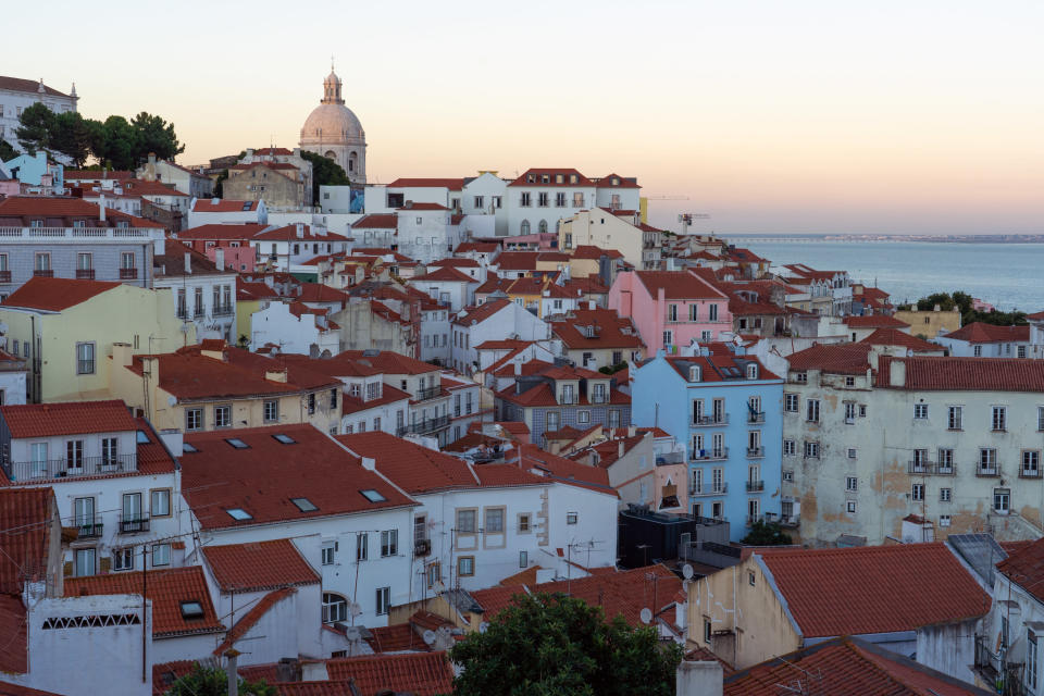 Panoramic view of the Alfama historic neighborhood of Lisbon at sunset from Portas do Sol viewpoint. Portugal.
